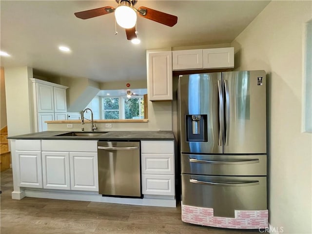 kitchen featuring ceiling fan, appliances with stainless steel finishes, sink, and white cabinetry