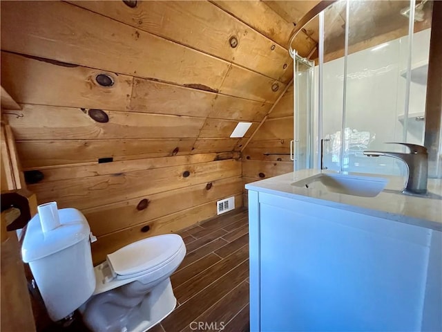 bathroom featuring toilet, wooden walls, wooden ceiling, vaulted ceiling, and vanity