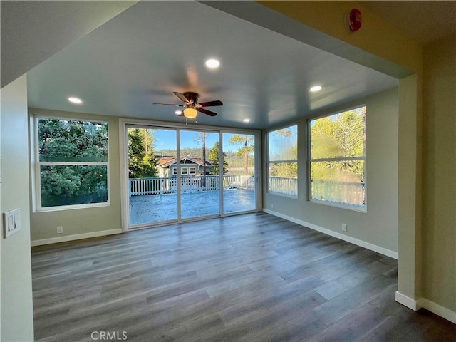 unfurnished sunroom with ceiling fan