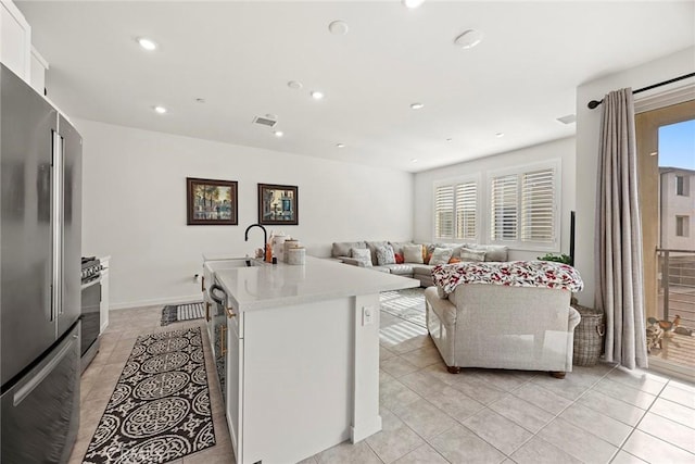 kitchen with white cabinetry, plenty of natural light, an island with sink, and stainless steel appliances