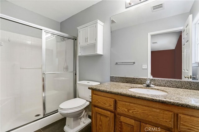 bathroom featuring tile patterned floors, vanity, an enclosed shower, and toilet