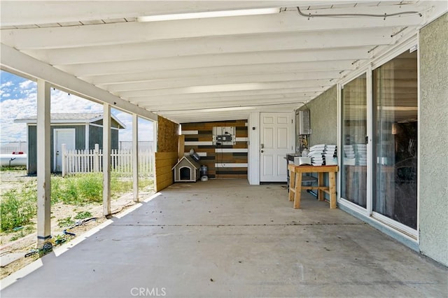 view of patio with a carport and a storage unit