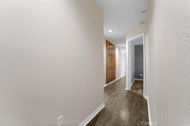 corridor with dark hardwood / wood-style flooring