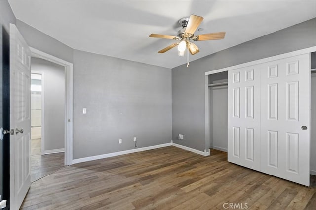 unfurnished bedroom with wood-type flooring, a closet, and ceiling fan