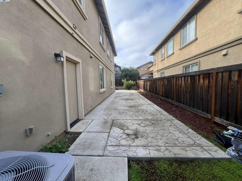 view of property exterior with cooling unit and a patio