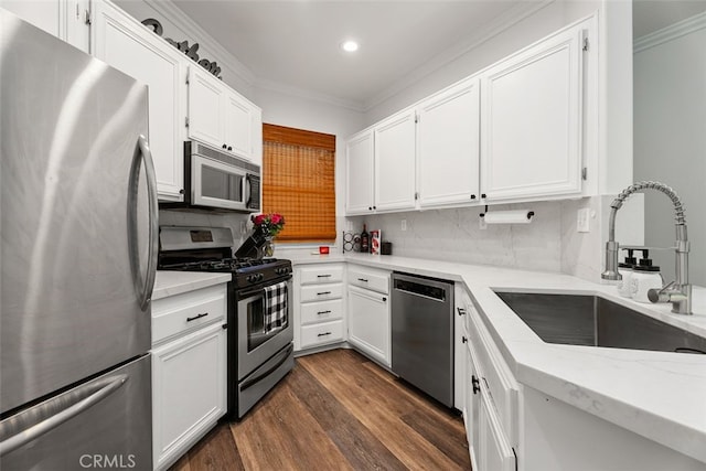 kitchen with sink, dark hardwood / wood-style floors, decorative backsplash, white cabinets, and appliances with stainless steel finishes