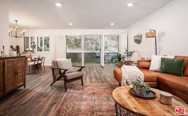 living room with a chandelier, dark hardwood / wood-style floors, and plenty of natural light