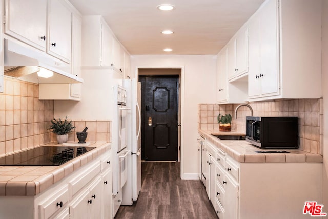 kitchen featuring white cabinetry, sink, tile counters, and black appliances