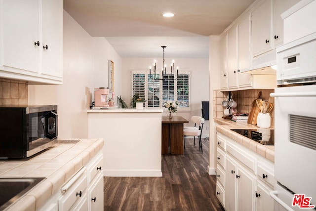 kitchen with white cabinetry, tile countertops, oven, and decorative light fixtures