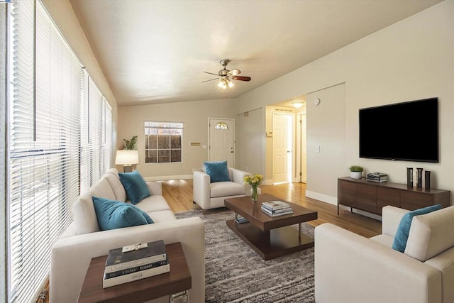 living room with ceiling fan, wood-type flooring, and vaulted ceiling