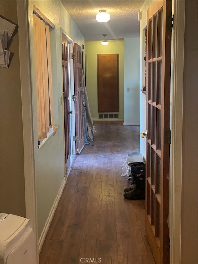 hallway with dark hardwood / wood-style flooring and a textured ceiling