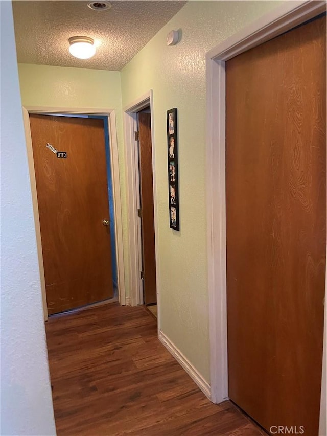 hall featuring dark hardwood / wood-style flooring and a textured ceiling