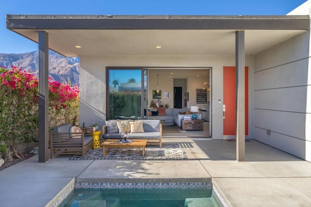 rear view of house with outdoor lounge area, a mountain view, and a patio