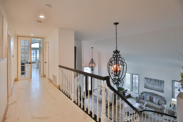 hall featuring french doors and a notable chandelier