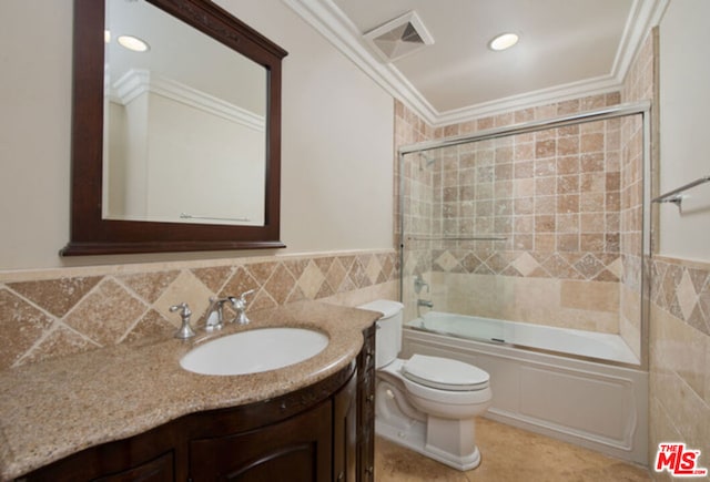 full bathroom featuring vanity, combined bath / shower with glass door, crown molding, and tile walls