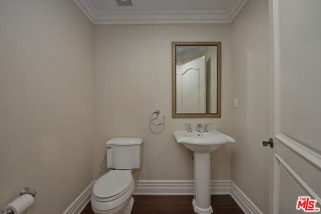 bathroom with hardwood / wood-style flooring, toilet, and ornamental molding