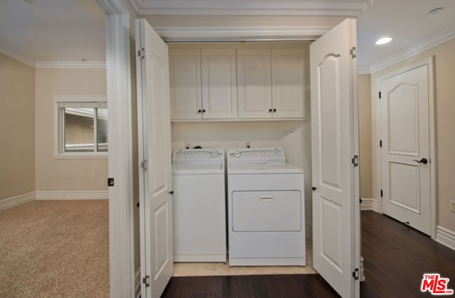 washroom with washer and dryer, hardwood / wood-style flooring, crown molding, and cabinets