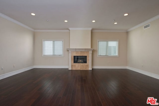 unfurnished living room with ornamental molding, a wealth of natural light, and dark wood-type flooring