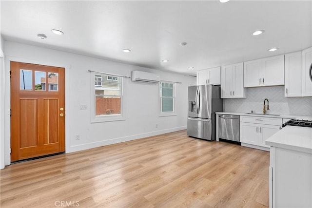 kitchen featuring white cabinets, stainless steel appliances, backsplash, and sink