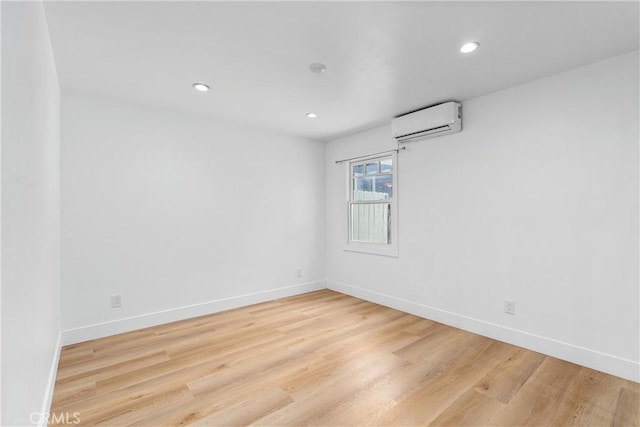 empty room featuring light hardwood / wood-style floors and an AC wall unit