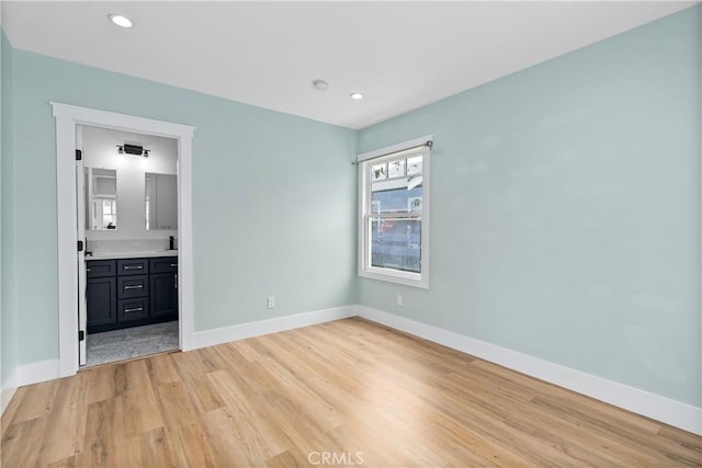 unfurnished bedroom with connected bathroom and light hardwood / wood-style flooring