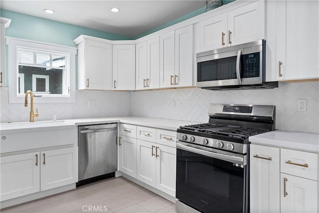 kitchen featuring appliances with stainless steel finishes, white cabinets, tasteful backsplash, and light tile patterned floors