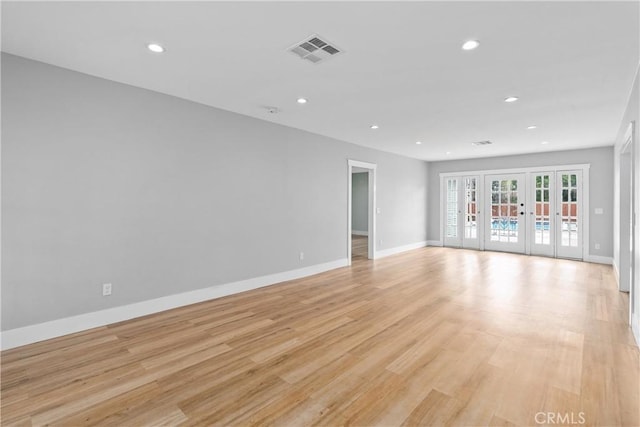 unfurnished room featuring french doors and light wood-type flooring