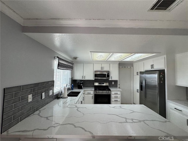 kitchen featuring decorative backsplash, stainless steel appliances, and white cabinetry