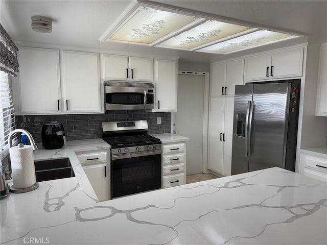 kitchen with sink, white cabinets, and appliances with stainless steel finishes