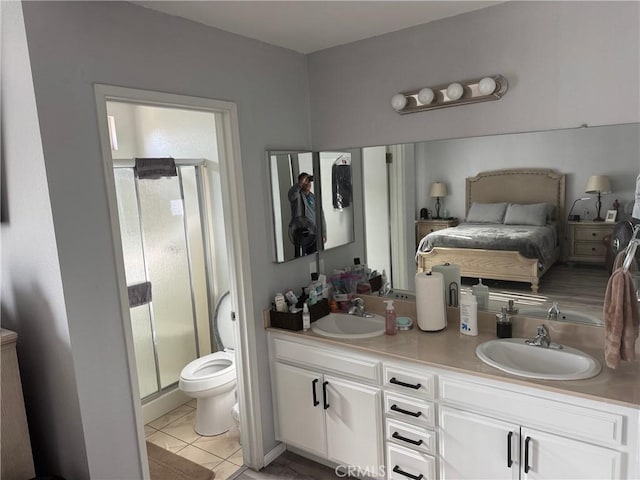 bathroom with tile patterned flooring, vanity, toilet, and walk in shower