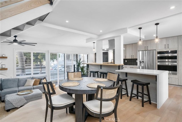 dining room featuring ceiling fan, light hardwood / wood-style floors, and sink