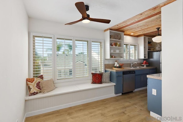 kitchen featuring pendant lighting, light wood-type flooring, stainless steel dishwasher, and blue cabinets