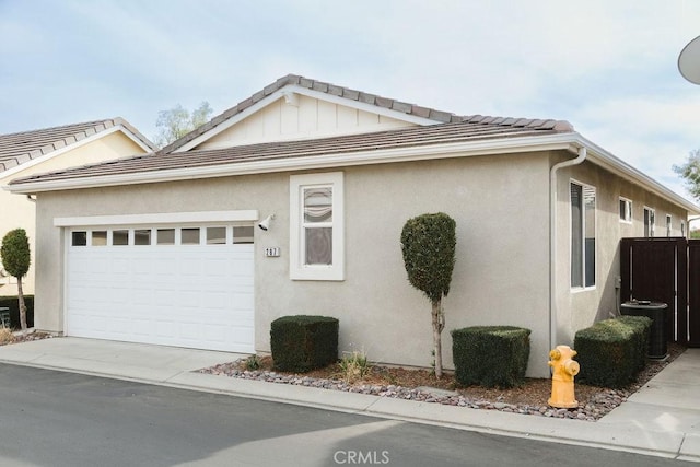 view of front of home with stucco siding, concrete driveway, an attached garage, cooling unit, and a tiled roof