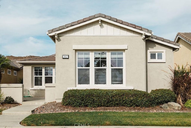 view of property exterior with a tiled roof and stucco siding