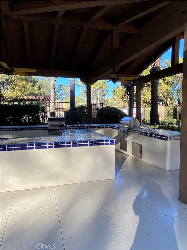 view of pool with grilling area, an outdoor kitchen, and fence