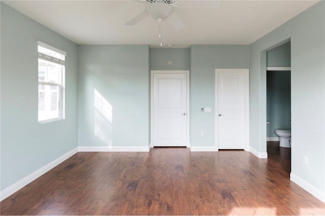 unfurnished bedroom with ensuite bathroom, ceiling fan, baseboards, and wood finished floors