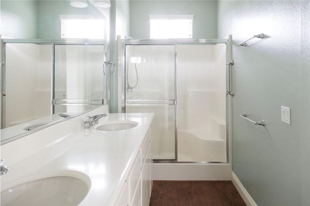 full bathroom with wood finished floors, a sink, and a shower stall