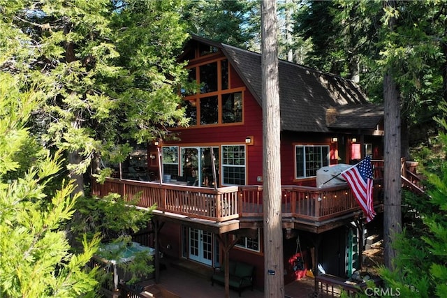 rear view of house with french doors and a wooden deck