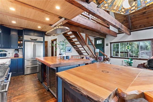 kitchen with high quality appliances, wooden ceiling, wooden counters, dark hardwood / wood-style floors, and blue cabinetry