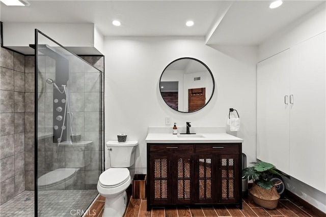 bathroom featuring hardwood / wood-style floors, vanity, toilet, and an enclosed shower