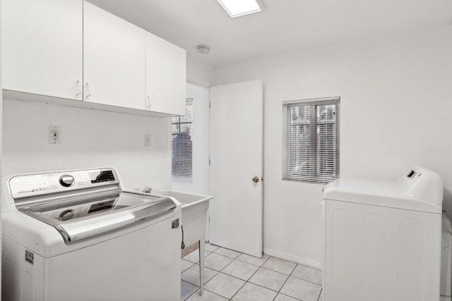 laundry room with washer and dryer, cabinets, light tile patterned floors, and sink