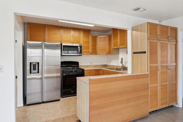 kitchen featuring light tile patterned flooring, sink, kitchen peninsula, and stainless steel appliances