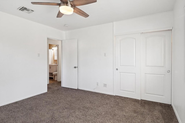 unfurnished bedroom with ceiling fan, a closet, and dark carpet