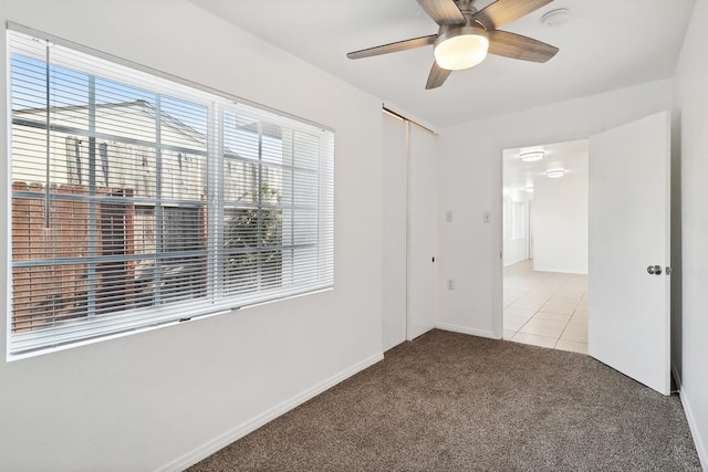 carpeted spare room with ceiling fan