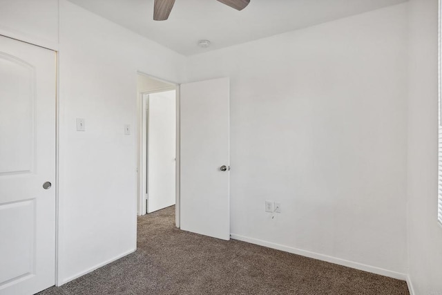 unfurnished bedroom featuring dark colored carpet and ceiling fan