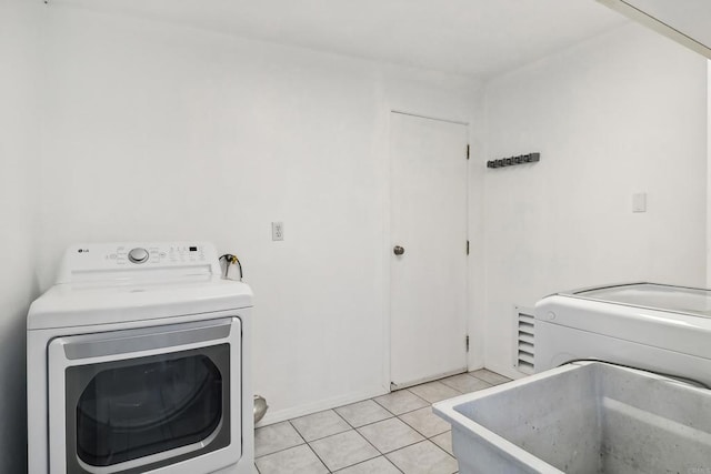 washroom with washing machine and dryer, sink, and light tile patterned floors