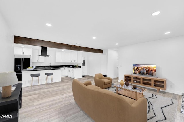 living room with beamed ceiling and light hardwood / wood-style floors