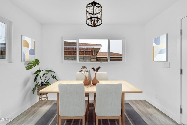 dining room with hardwood / wood-style flooring and a chandelier