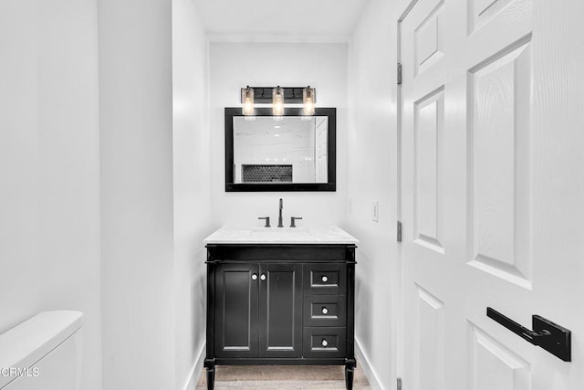 bathroom featuring hardwood / wood-style floors, vanity, and toilet