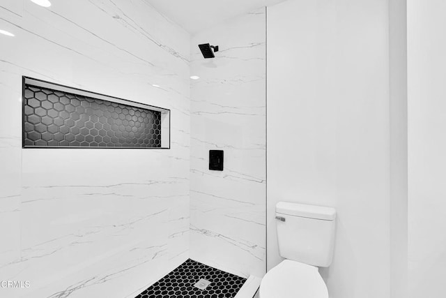 bathroom featuring toilet and tiled shower